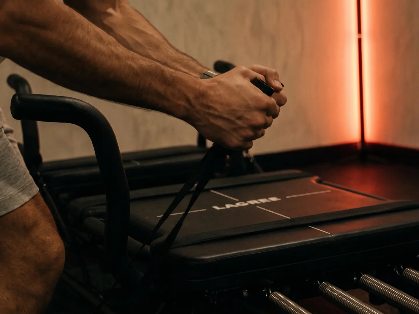 Deux mains tirent les sangles d’une Micro Pro, avant-bras tendus, la barre LED rouge à droite