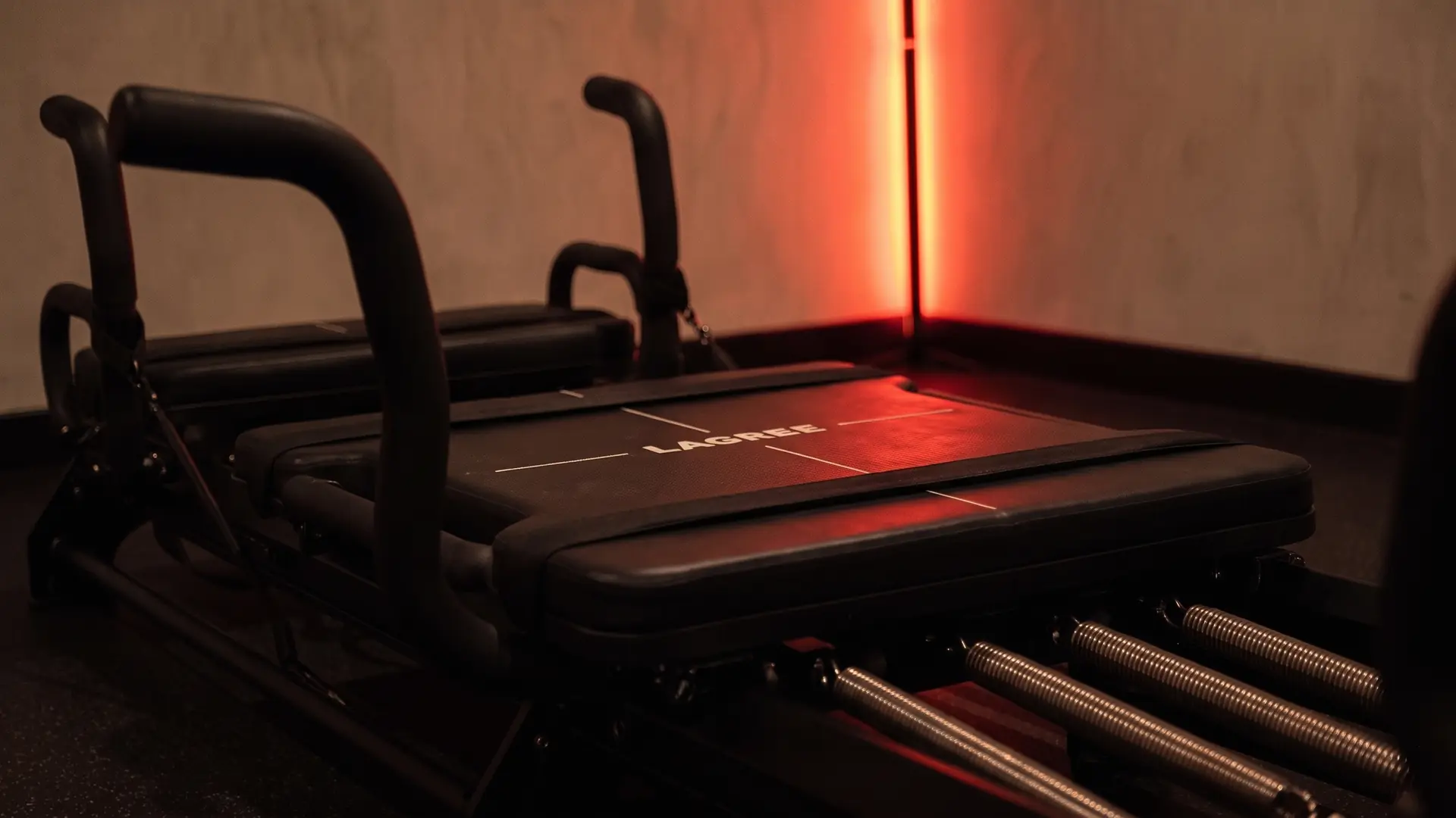 Une machine Micro Pro prête pour la séance, chariot et poignées sous la lumière rouge de la barre LED