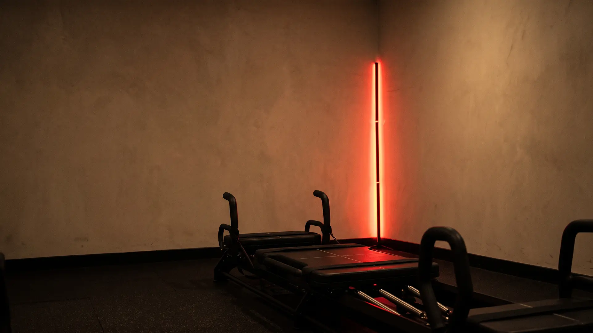 Le studio RYTHM avant la séance : le mur greige, la barre LED rouge allumée et les machines Micro Pro