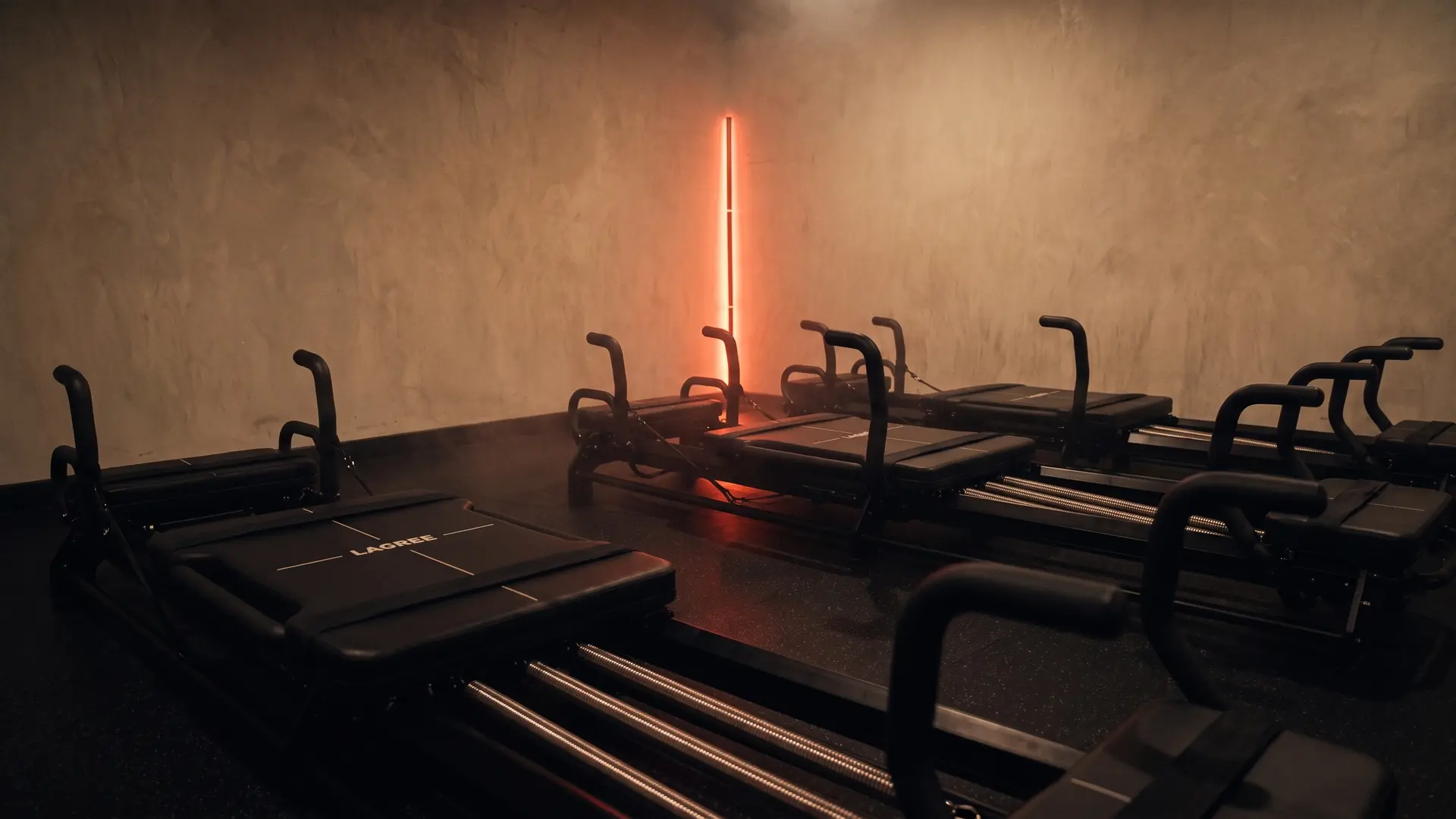 Une rangée de machines Micro Pro vue au ras du sol, la barre LED se reflète sur le sol noir